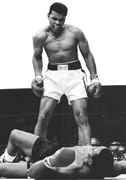 Mohammed Ali, de pie, observa a otro boxeador en el piso.