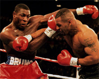 Mike Tyson (derecha) en sus años felices golpea a otro boxeador en el ring.